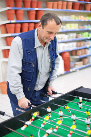 Man plays into  table football in store