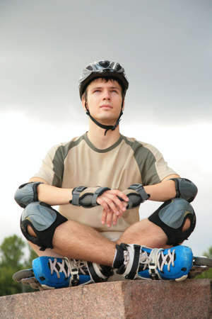 Boy on rollerblades sits with crossed legs yoga poseの写真素材