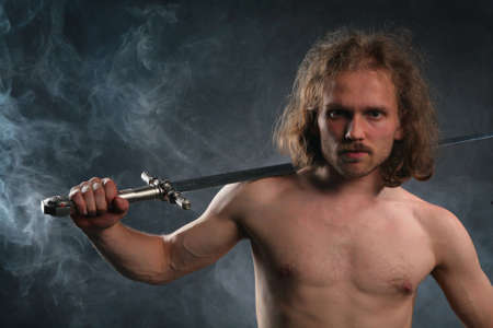 Man with sword in smokeの写真素材