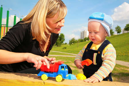 mother plays with child with toy carの写真素材