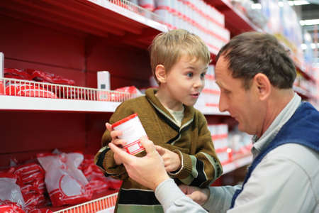 Grandfather and grandson choose conserve in food shopの写真素材