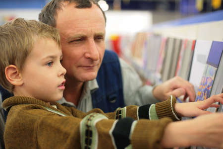 Grandfather with grandson in bookstoreの写真素材