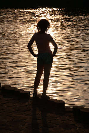 Female silhouette near water on  sunsetの写真素材
