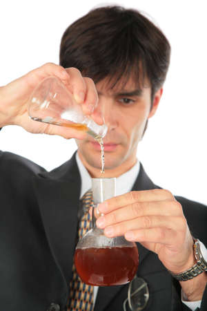 Scientist pours liquid from one flask in anothe