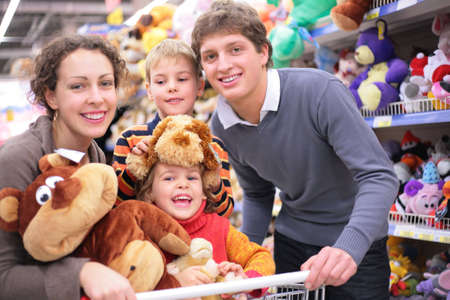 Family of four in shop with soft toys, focus on little girlの写真素材