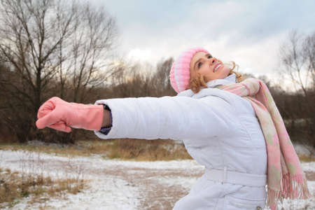 young beauty girl  in wood in winter with stretched hands
の写真素材