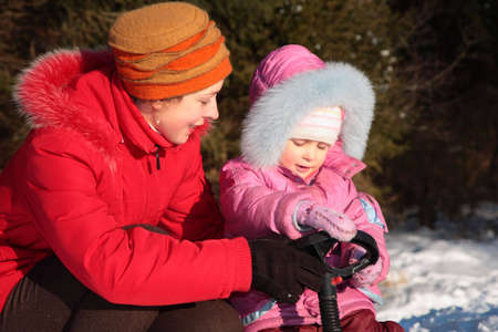 Mother and daughter with snow scooter 