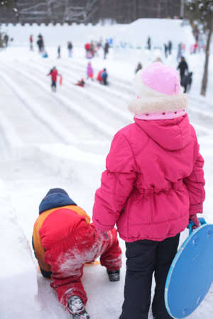 Children on ice slope in parkの写真素材