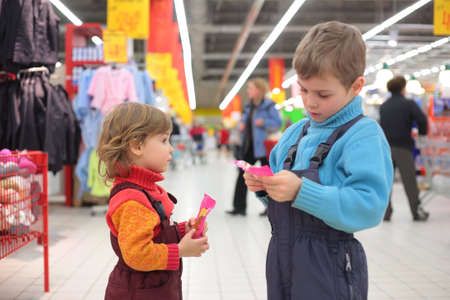 Children with sweetmeats in supermarket, focus on little girlの写真素材