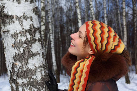 Young beautiful woman in birch wood in winterの写真素材