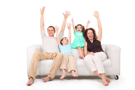 Parents and children with rised hands  on white leather sofaの写真素材