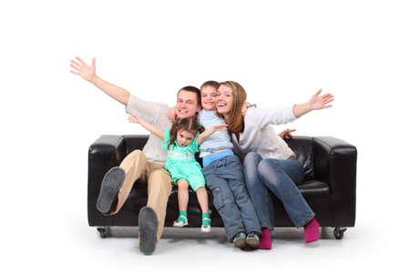 Happy family with two children on black leather sofaの写真素材