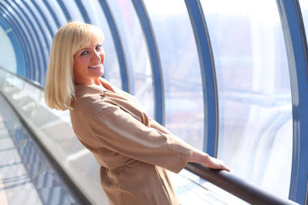 Happy middleaged woman in glass hallの写真素材