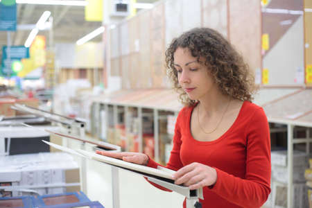 young woman in shop chooses ceramic tileの写真素材