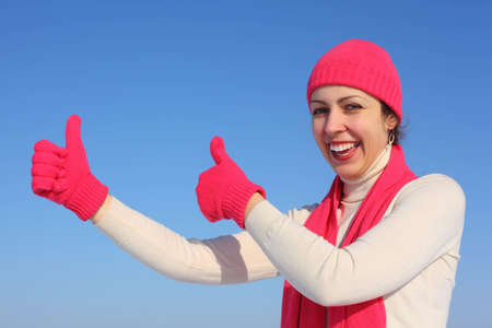 Young woman in red gloves shows gesture okの写真素材
