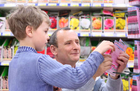 elderly man with boy in shop of seedsの写真素材