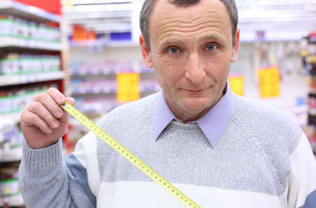 elderly man in shop with roulette in hands, focus on rouletteの写真素材