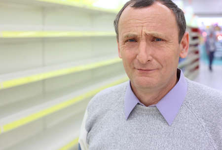 elderly man face and empty shelves in  shop の写真素材
