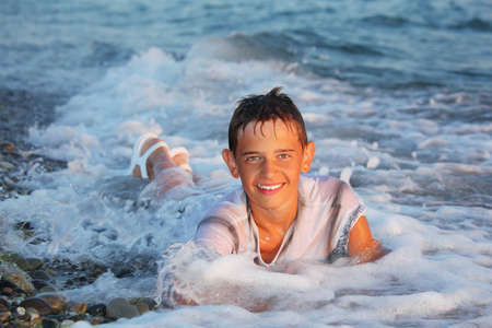 teenager boy swim in clothes in seaの写真素材
