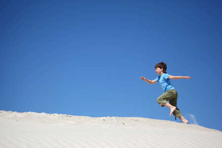 boy runs on sandの写真素材
