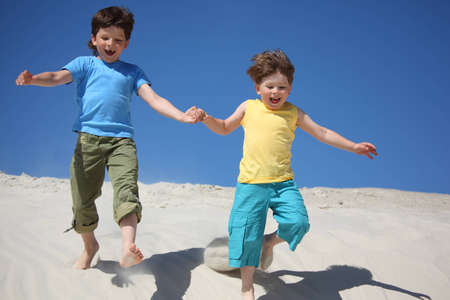 Two boys run on sandの写真素材