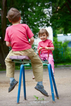The boy and the girl on a swing in parkの写真素材