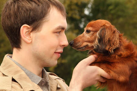 Young man and his adorable dachshund closeupの写真素材