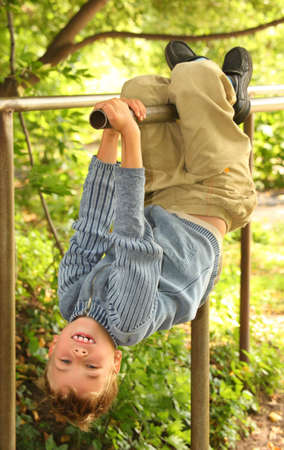 boy hangs on bars headfirst