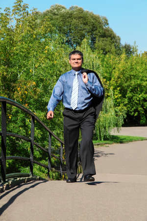 businessman walks outdoor in summerの写真素材