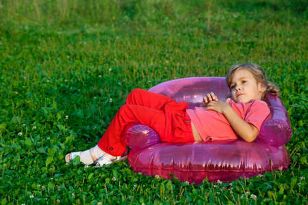 girl looking at the sky in inflatable armchair の写真素材