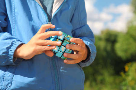 hands of boy  with earth magic cube outdoor in summerの写真素材
