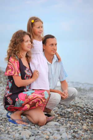 Happy family with little girl on stony beach, Looking afarの写真素材