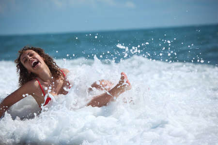 beauty happy girl sits in sea surf