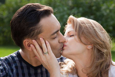 married couple kissing outdoors