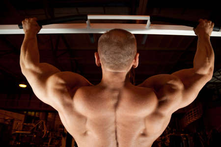 bodybuilder back pull-up in training room