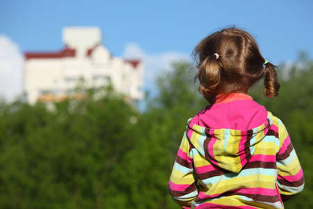 Little girl from back,  trees  and housesの写真素材