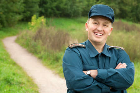 smiling officer of rescue service standing on footpath outdoors