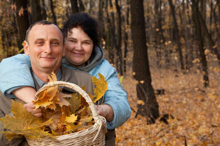 Old man and old woman with basket of maple leavesの写真素材