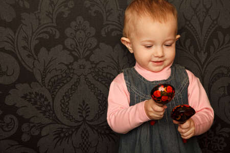 Portrait of little girl with Russian traditional spoons in her hands against ornamental wall.の写真素材