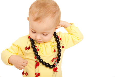 Portrait of little girl eyes set down in yellow shirt with beads on white background.の写真素材