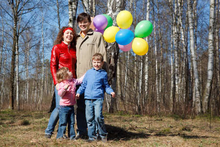 Parents with the daughter and the son walk in park with balloons, a sunny day.の写真素材