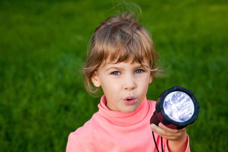 girl playing with lantern. Portrait of girl against a grass. grass backgroundの写真素材