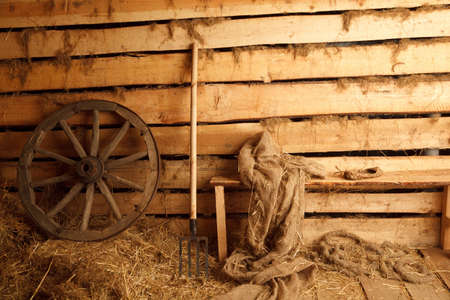 Interior of village building. Wheel, pitchfork, bench, cloth, bast shoe.の写真素材