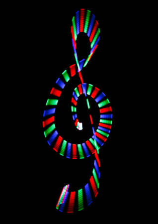 Multi-coloured shone treble clef on black background. Musical symbol.