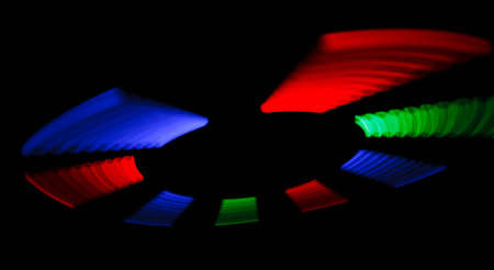 Rotating multicolored blinking LEDs mark on a black background.の写真素材