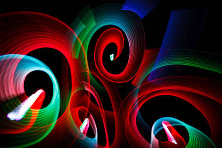 Abstract luminous patterns in form of spirals on black background.