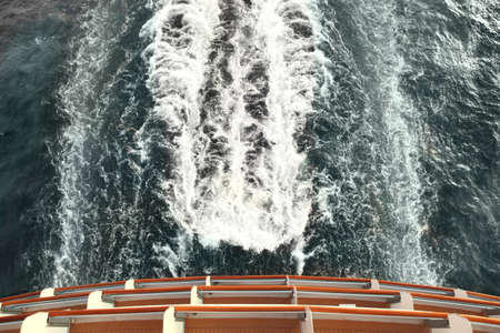 ship deck and trail with waves and foam in ocean view from aboveの写真素材