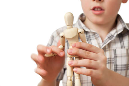 boy in checkered shirt is played by wooden little manikin isolated on white background, little...