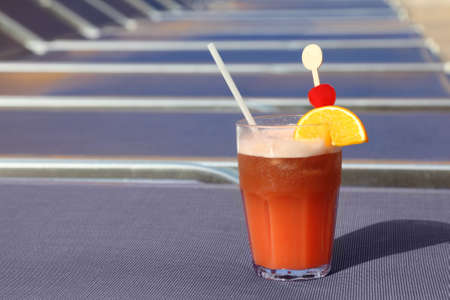 cocktail with fruits in glass on blue beach armchair in cruise liner