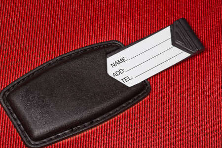 Label with identification data on red textural fabric, diagonal shot